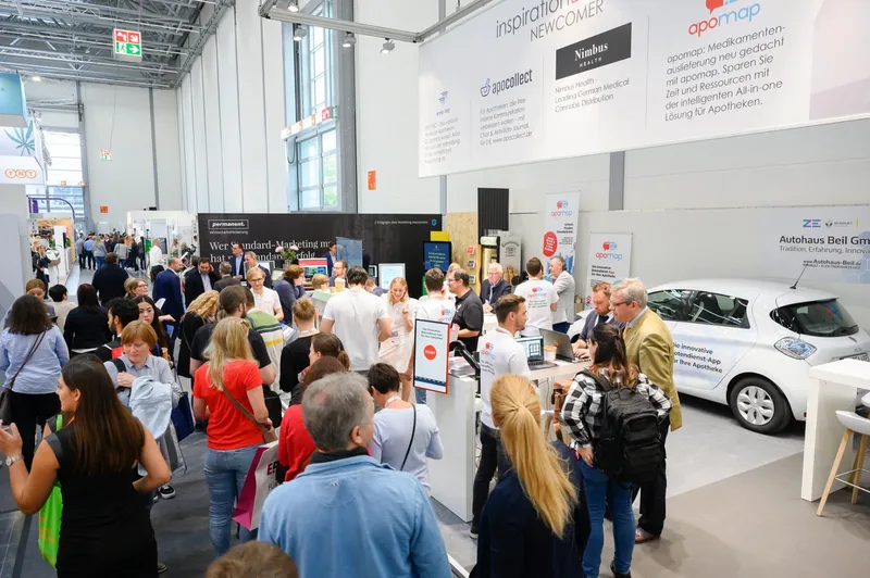 apomap Messestand auf der expopharm mit Besucher:innen am Stand